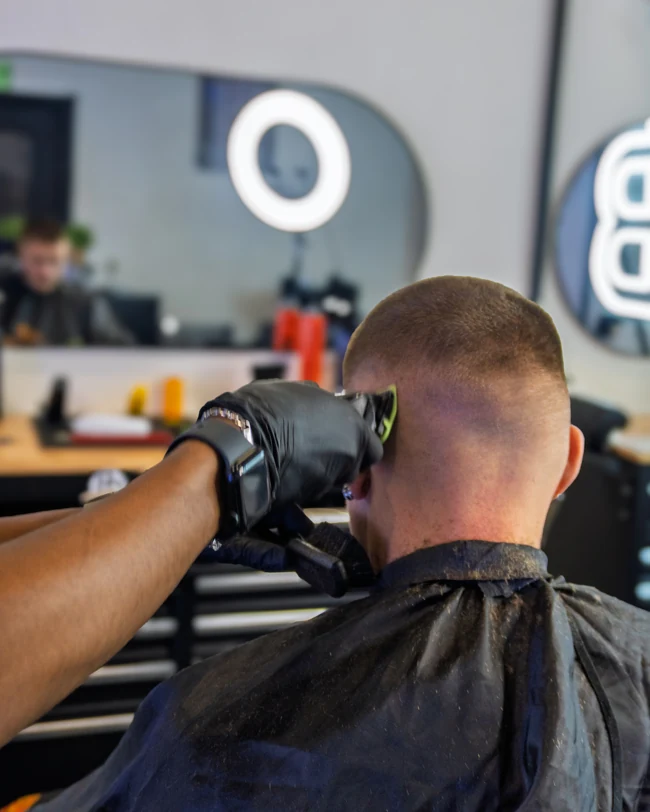 Een barber werkt een kapsel zorgvuldig af